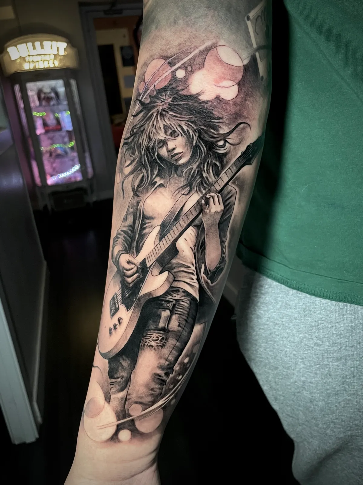 Black and grey realism rock guitarist portrait playing electric guitar forearm tattoo by Paul Michael Andras