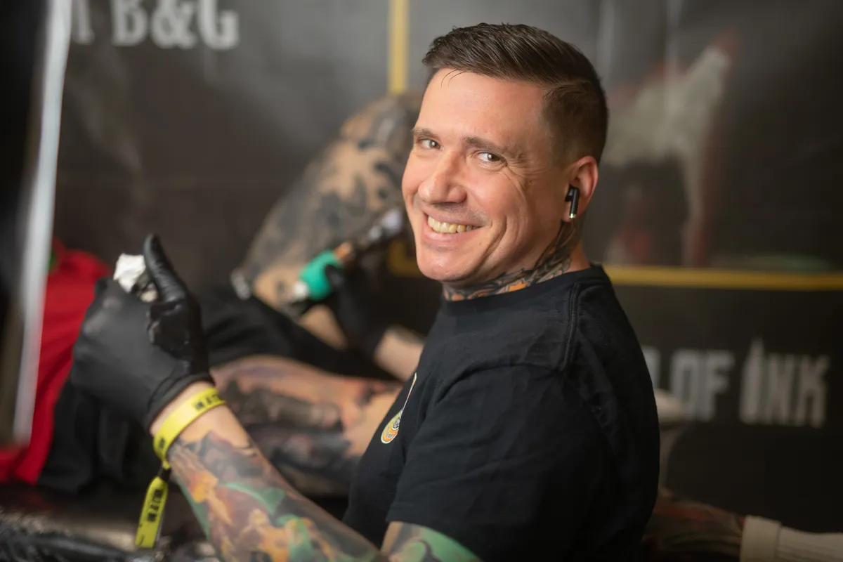 Paul Michael Andras tattooing at tattoo convention - professional realism tattoo artist at work