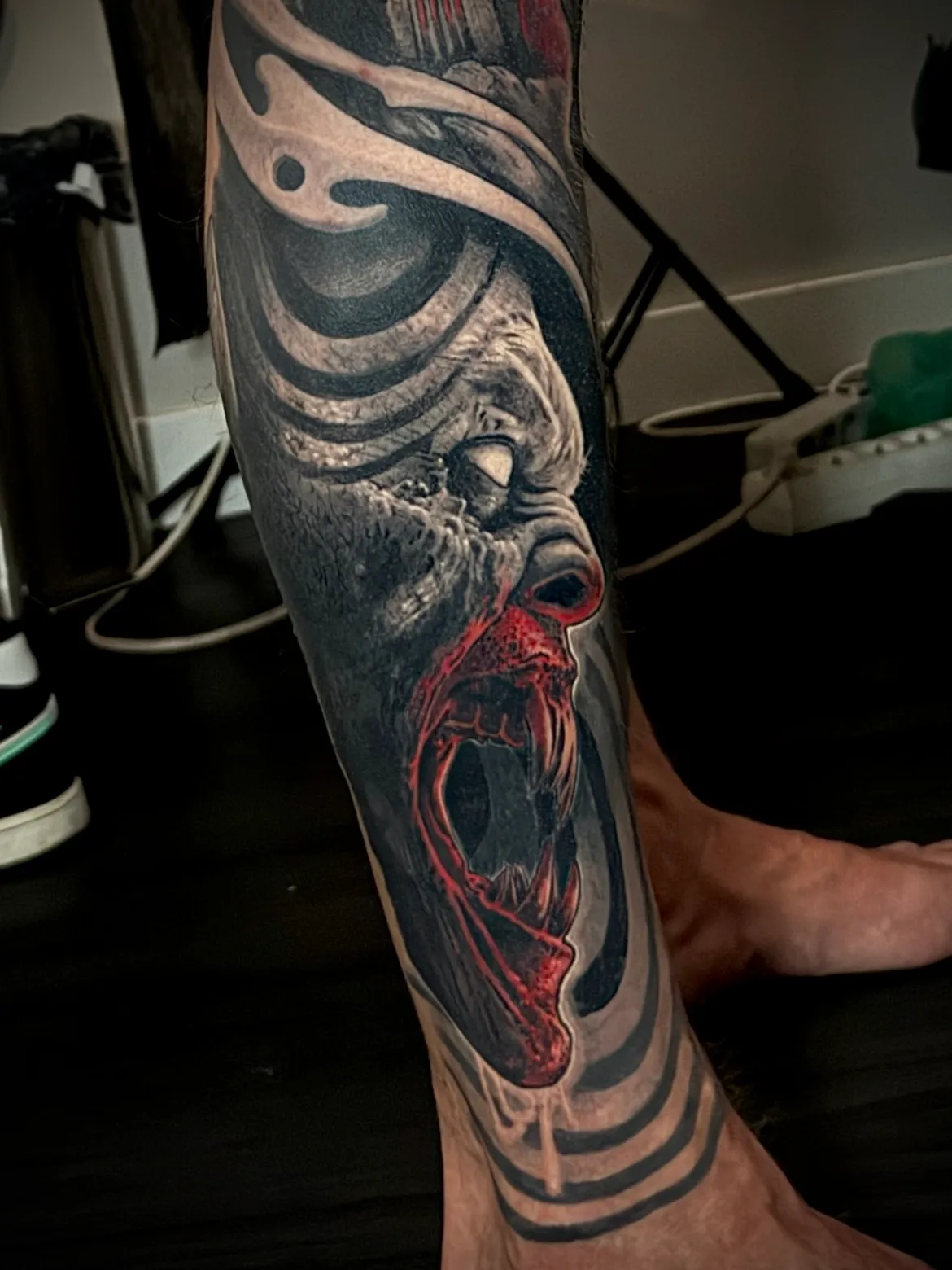 Black and grey realism screaming face with red interior detail on full leg sleeve tattoo by Andras Tattoo