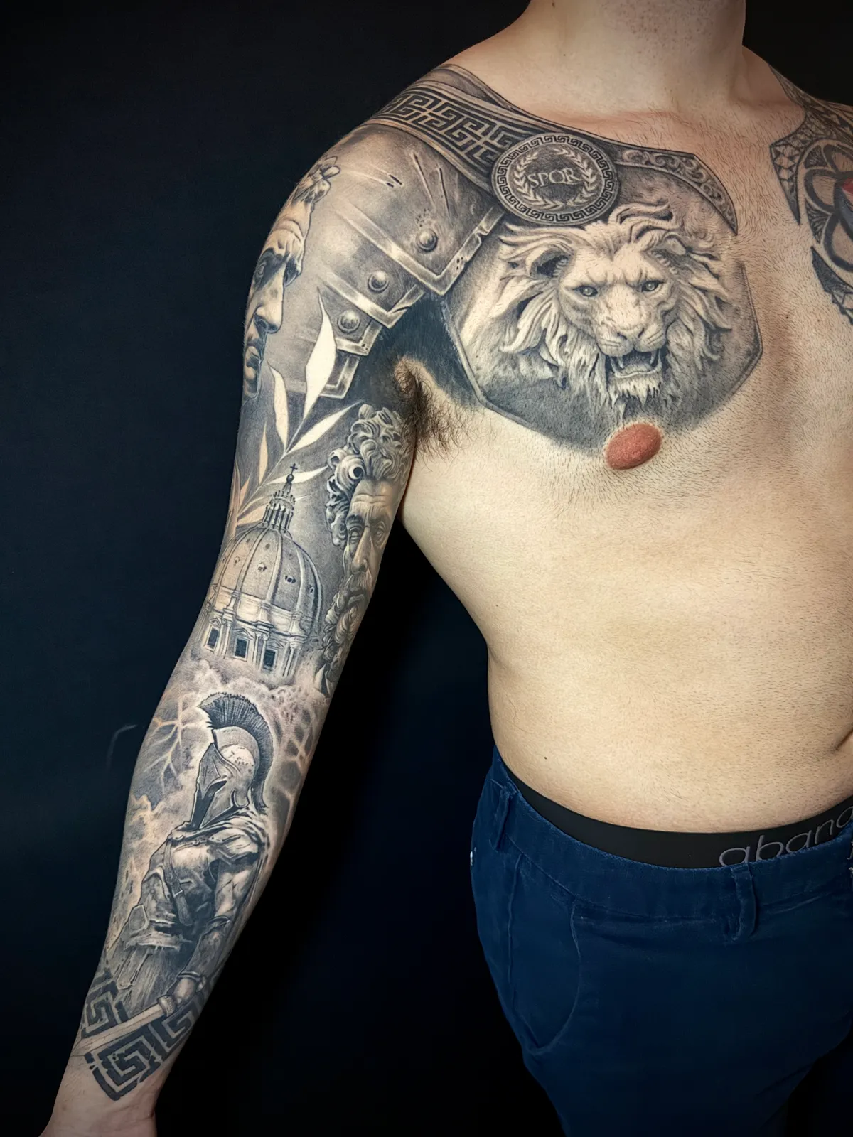 Black and grey realism Roman armor full sleeve and chest piece with lion, gladiator and Greek key border by Paul Michael Andras