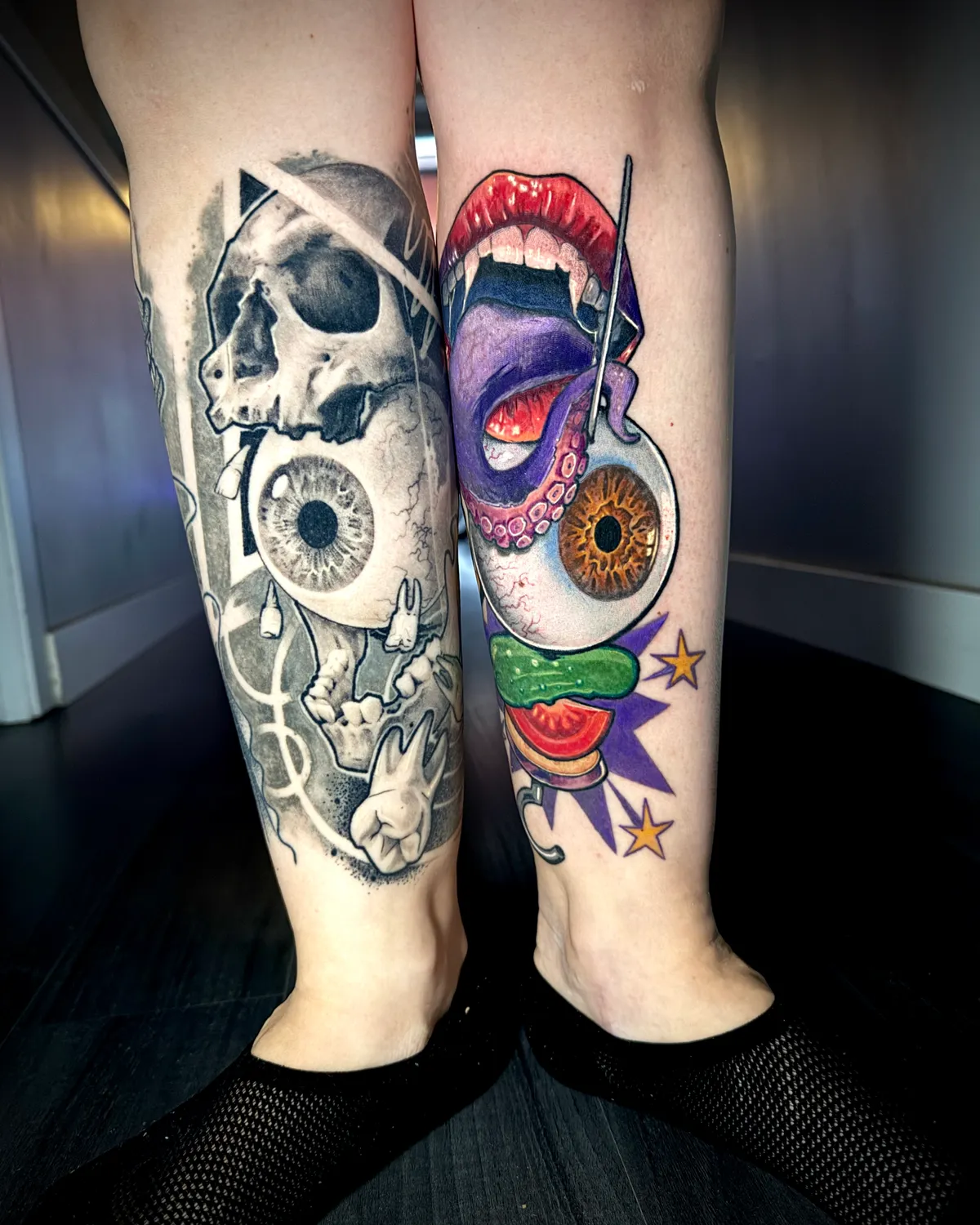 Matching black and grey skull with eyeball and color pop art legs tattoo pair by Andras Tattoo