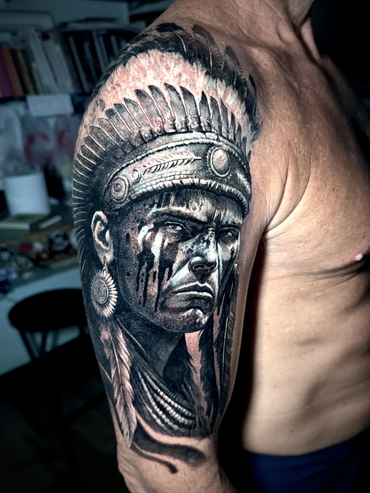 Black and grey realism Native American warrior chief portrait with feathered headdress shoulder tattoo by Paul Michael Andras
