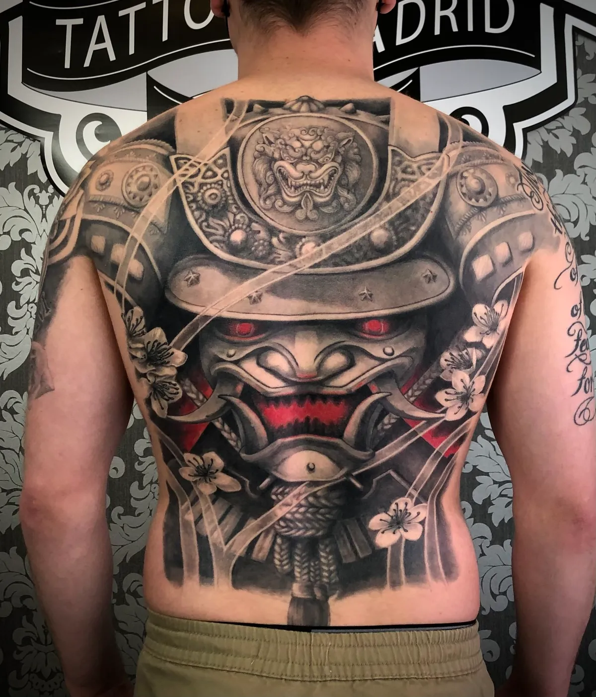 Black and grey realism Japanese samurai mask with cherry blossoms full back piece tattoo by Andras Tattoo