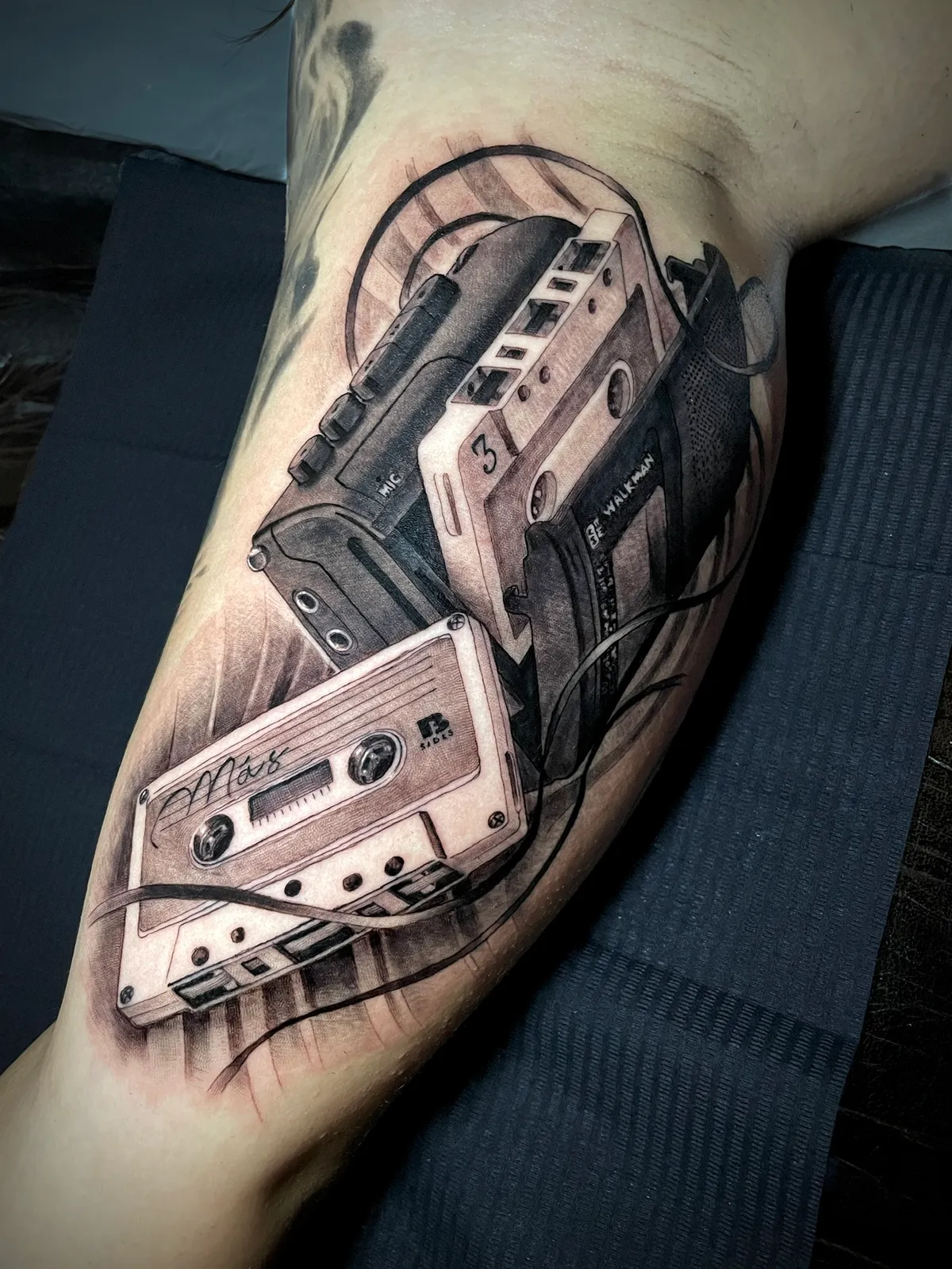 Black and grey realism vintage cassette tapes with headphones nostalgic still life tattoo by Paul Michael Andras